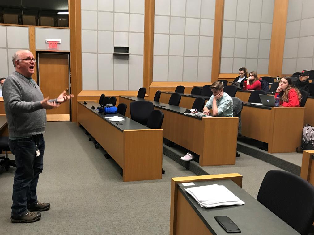 Bill Kelly talks with students about where to find background information for news stories.